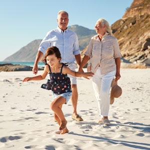 An older couple and their granddaughter running on the beach in Maryland Guardianship. - Michael Cochran Law Offices