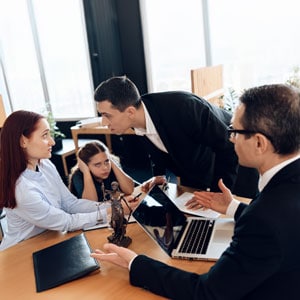 A group of professionals in business attire engaged in discussion around a conference table, focusing on custody orders. - Michael Cochran Law Offices.